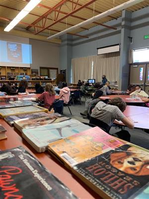 A multcolib librarian talks about a book with students listening